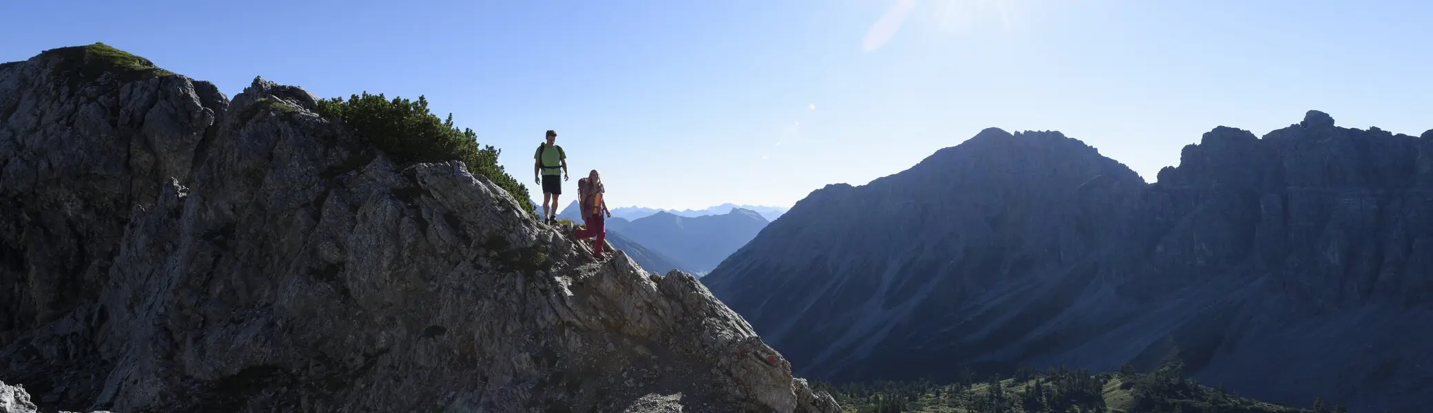 Panoramaaufname von Berggipfeln mit zwei Wanderern | © DAV/Wolfgang Ehn